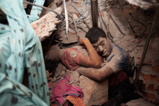 Two dead victims cling to one another in the rubble