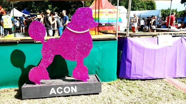 A sign of a purple poodle that says: Acon