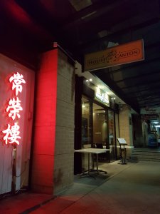 Night time, the exterior of House of Canton includes Cantonese writing in neon red sign and the entrace is lit up