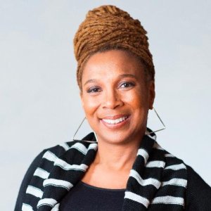 Prof Kimberlé Crenshaw is smiling. Her hair is worn high in a bun and she wears beautiful large earrings