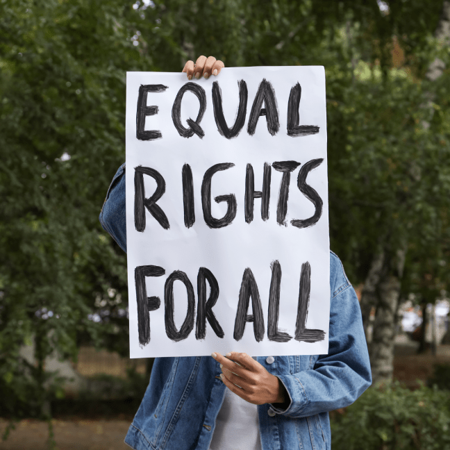 A person of colour is unseen behind a sign saying: Equal rights for all