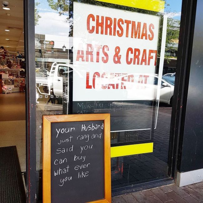 Entrance to Christmas arts and craft shop with a sign outside as above, “Your husband just rang and said you can buy whatever you like”.