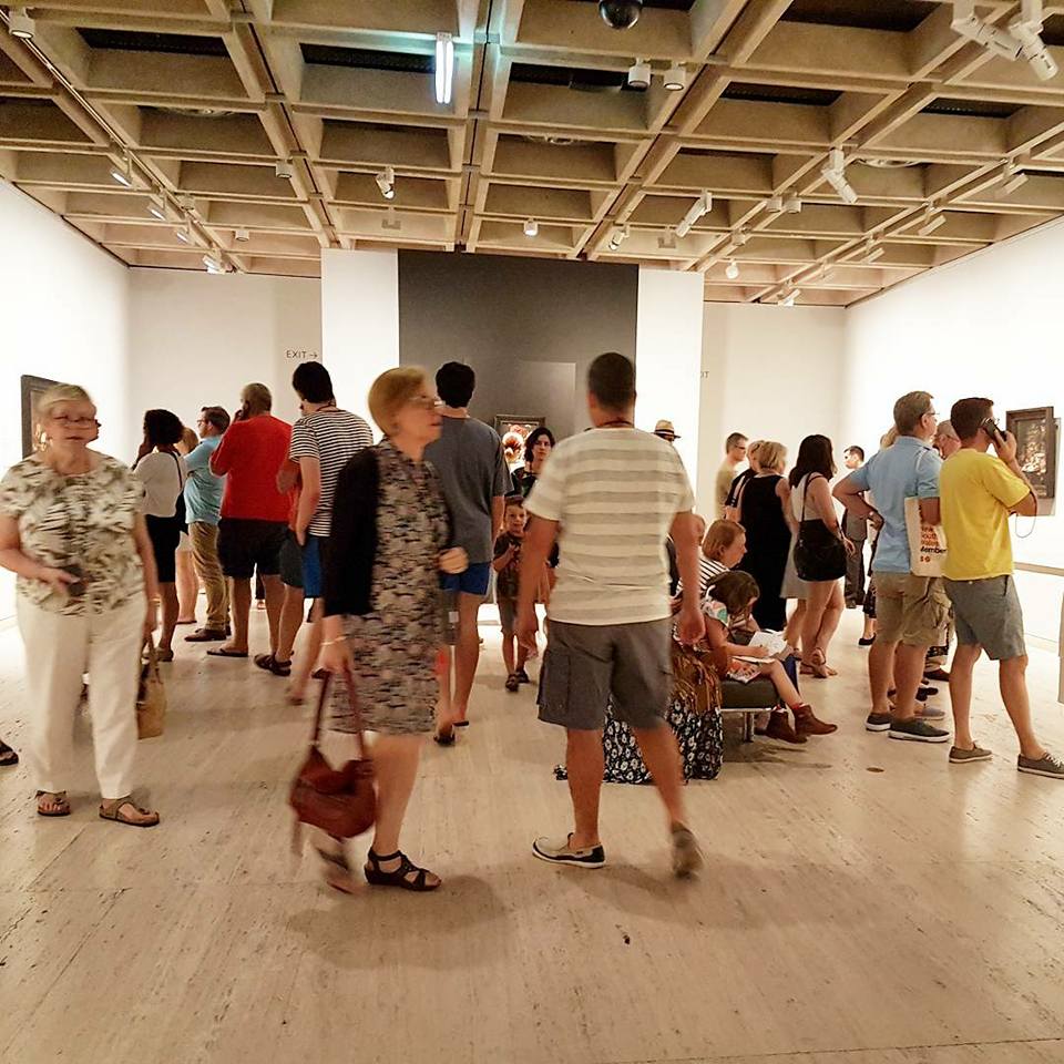 Visitors walk around the busy exhibition