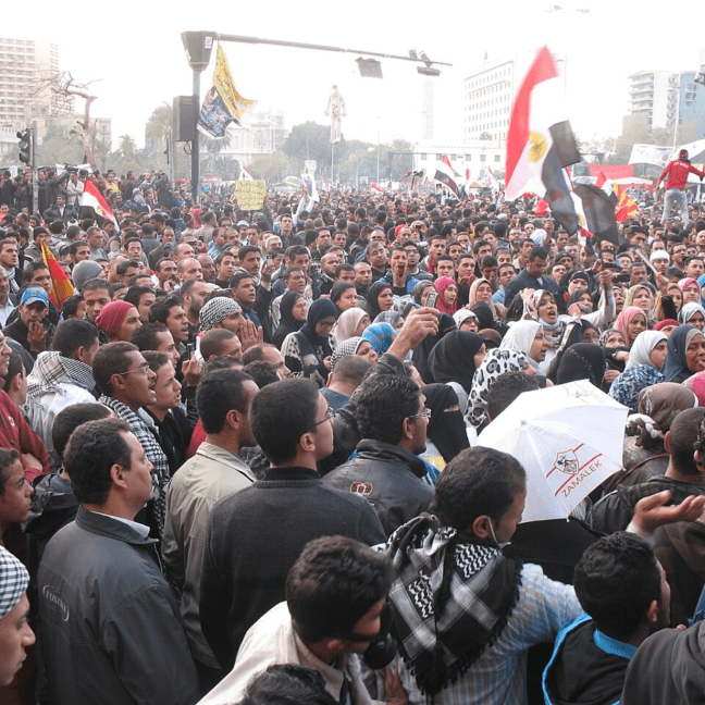 Egyptians hold flags and umbrellas in a protest
