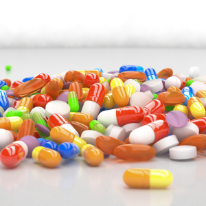 A mountain of colourful pill capsules piled on a white surface
